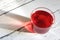 Red hot hibiscus tea in a glass mug on a wooden background. Red tea karkade. Healthy tea.