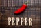 Red hot mexican pepper on wooden board with letters