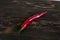 Red hot pepper on a dark brown background.