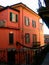 Red house on narrow street in the village of Bellagio, Italy on Como lake