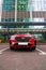 Red Hyundai Tucson N-Line front view. Korean compact crossover SUV parked in front of modern building with glass facade