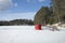 Red ice fishing shelter on a remote Minnesota lake