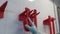 Red industrial brushes on a white wall with tiles and hand of worker in glove.