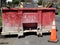 Red industrial dumpster on neighborhood street