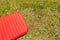 Red inflatable camping mattress on the green grass