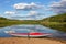 Red inflatable kayak on the sandy shore