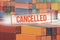 Red inscription cancelled on a blurred background of containers at docks.