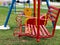 Red iron swing and yellow swing shape duck Set in a playground.