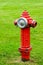 Red isolated fire hydrant sits in a freshly cut grass field
