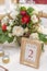 Red and ivory floral arrangement prepared for reception, wedding table with candle and setting, winter concept