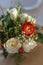 Red and ivory floral arrangement prepared for reception, wedding table with candle and setting, winter concept