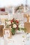 Red and ivory floral arrangement prepared for reception, wedding table with candle and setting, winter concept