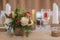 Red and ivory floral arrangement prepared for reception, wedding table with candle and setting, winter concept