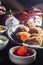 red jelly falling from a spoon with fried dumplings in the background