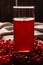 Red juice from viburnum in a glass on a dark background. Near viburnum berries, and linen cloth. Healthy food