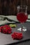 Red juice from viburnum in a glass on a stem on a dark background. Near viburnum berries and linen napkin. Healthy food