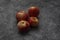 Red juicy apple lies on a gray stone background. Several Fruits with yellow