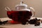 Red karkade tea in teapot on the wooden table