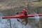 Red kayak floats along the river in early spring