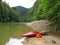 Red kayak on the river bank