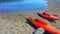 Red kayaks. Beached on sandy shore with blue waters.