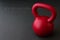 Red kettlebell on a black gym floor