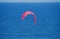 RED KITE SURFER SAIL OVER BLUE SEA