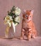 Red kitten with bouquet of wild roses