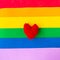 Red knitted heart on LGBTQ colors flag