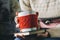 Red Knitted woolen cup with heart pattern in female hands.