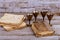 Red kosher wine with a white plate of matzah or matza and a Passover Haggadah on a vintage wood background presented as a Passover