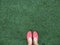 Red lady shoes on feet on green grass