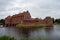 The red Landskrona castle stands within a moat by the coast in the city of Landskrona in southern Sweden