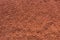 Red lava sand on tennis court