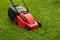 Red lawnmower on green grass