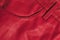 Red leather clothes texture. Stitched pocket.