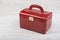 Red leather jewelry box on white wooden background
