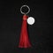 Red Leather Tassel key ring on black wooden background. Fashion leather key chain for decoration