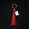 Red Leather Tassel key ring on black wooden background. Fashion leather key chain for decoration