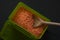 Red lentil in green plastic box on dark wooden table