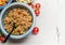 Red lentil salad in bowl with spoon on light rustic background, top view