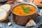 Red lentil soup with spices in a copper saucepan, close up