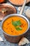 Red lentil soup with spices in a copper saucepan, top view