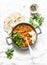 Red lentils dhal and paratha flatbread - healthy vegetarian dinner in Indian style on light background