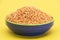 Red lentils pile isolated on yellow background, also known as Dry orange lentil grains,raw daal, masoor dhal