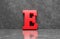 Red letter E on concrete wall an floor background series 3D render