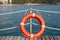 Red life buoy near the fence on a wooden pier. bright sunny weather