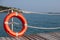 Red life buoy near the fence on a wooden pier. bright sunny weather