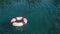 Red life buoy over clear blue sea or ocean water background, swimming pool