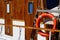 Red lifebuoy attached to the railing of a boat deck